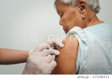 doctor make injection vaccine to senior woman 117206511
