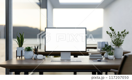 A computer desk in a modern office surrounded by large windows with a lake view, a computer mockup A computer desk in a modern office surrounded by large windows with a lake view, a computer mockup 117207050