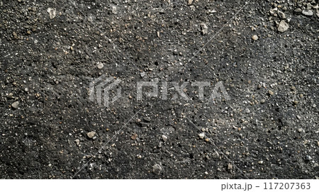 A detailed view of the texture of black asphalt surface 117207363