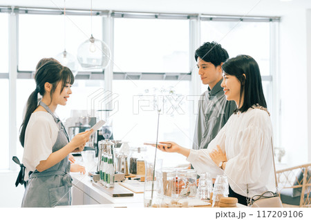 カフェでスマホ決済をする夫婦 カフェでスマホ決済をする夫婦 117209106