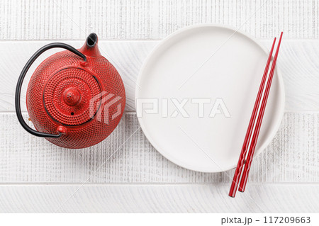 Table adorned with cherry blossom branch and chopsticks, epitomizing Japanese food culture Table adorned with cherry blossom branch and chopsticks, epitomizing Japanese food culture 117209663