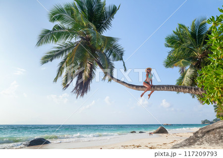 Young girl on palm on sea beach 117209793