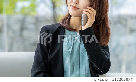 スマートフォンで話す笑顔の日本人ビジネスウーマン 117209874