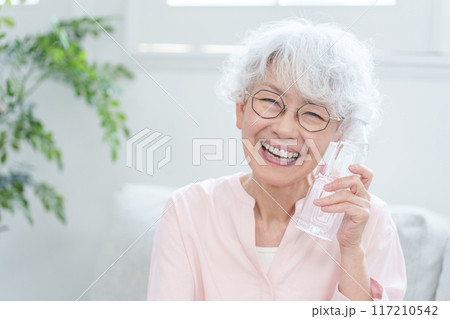 ペットボトルの水を飲むシニア女性 117210542