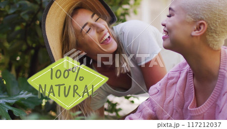 Image of 100 percent natural text over diverse female couple working in garden 117212037