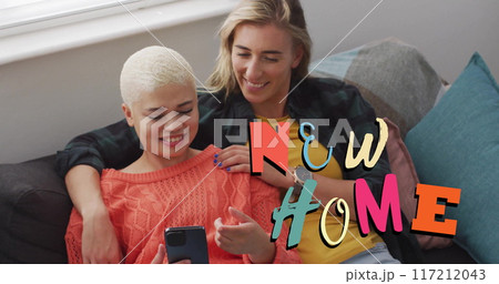 Image of new home text over gay lesbian couple using smartphone at home Image of new home text over gay lesbian couple using smartphone at home 117212043