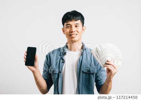 Portrait smiling Asian young man holding a bunch of money and mobile phone studio shot isolated white background, happiness and excitement man in dollar banknotes with smartphone blank screen Portrait smiling Asian young man holding a bunch of money and mobile phone studio shot isolated white background, happiness and excitement man in dollar banknotes with smartphone blank screen 117214450