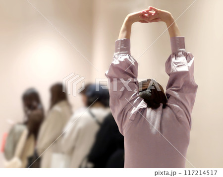 列に並ぶ女性たちと最後で伸びをする女性 117214517