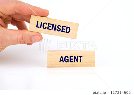Text LICENSED AGENT written phrase made of wooden blocks is laid out on a white background Text LICENSED AGENT written phrase made of wooden blocks is laid out on a white background 117214609