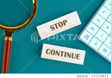 Conceptual symbol. Copy space. Stop or continue words written The inscription is made up of wooden toy blocks 117214611