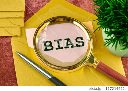 Business concept. The word Bias written through a magnifying glass in a letter peeking out of an envelope 117214622