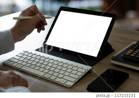 A businessman holds a mockup. iPad digital tablet with blank screen Mockup replaces your design mockup in the office. 117215131