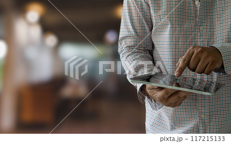 businessman holds a mockup. iPad digital tablet in office multitasking searching the internet businessman holds a mockup. iPad digital tablet in office multitasking searching the internet 117215133
