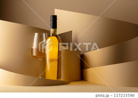 Bottle and glass of white wine on a beige background. 117215590