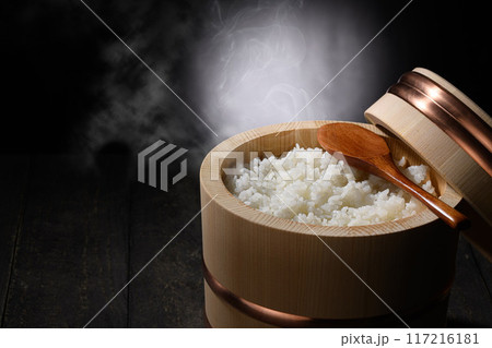 お櫃に入れた炊きたて熱々の湯気が上がるご飯 (黒背景) お櫃に入れた炊きたて熱々の湯気が上がるご飯 (黒背景) 117216181