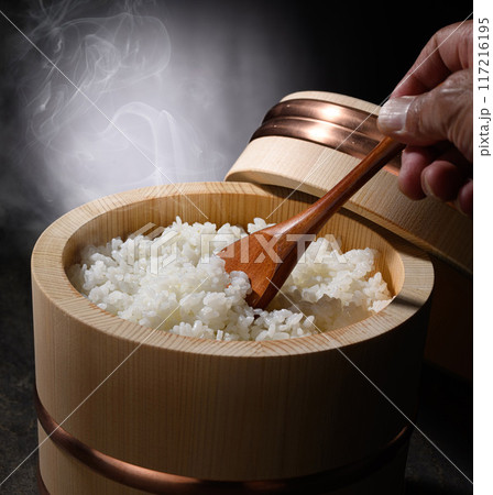 お櫃に入れた炊きたて熱々の湯気が上がるご飯 (黒背景) お櫃に入れた炊きたて熱々の湯気が上がるご飯 (黒背景) 117216195