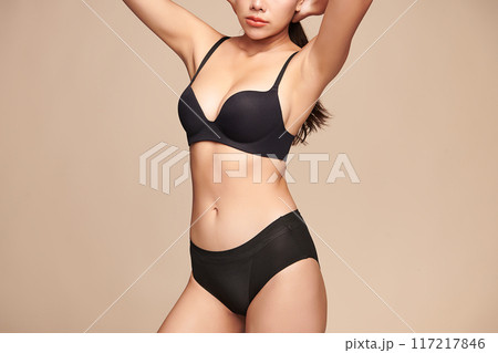 Confident beautiful young asian woman posing in black lingerie on beige background, Perfect body, Confident beautiful young asian woman posing in black lingerie on beige background, Perfect body, 117217846