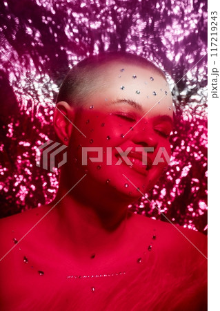 Close up fashion portrait of smiling young woman with crystal makeup over glittering red background Close up fashion portrait of smiling young woman with crystal makeup over glittering red background 117219243