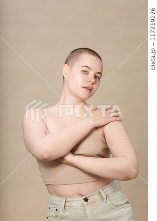 Minimal portrait of young girl with short hair posing elegantly on neutral background in studio Minimal portrait of young girl with short hair posing elegantly on neutral background in studio 117219276