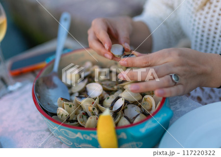 Woman eating seafood in a restaurant. Steamed mussels in white wine sauce. Food Concept Woman eating seafood in a restaurant. Steamed mussels in white wine sauce. Food Concept 117220322