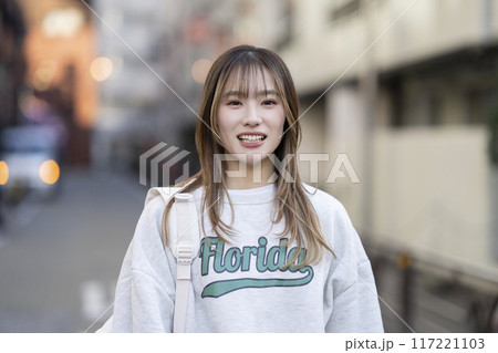 カメラ目線で笑顔の20代前半の女性 117221103