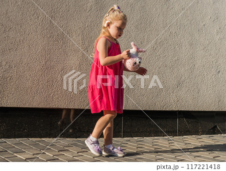 Funny baby with cochlear implant walks outdoor copy space. Hearing aid and medicine innovating technology concept. Diversity and Inclusion and people with disability concept. 117221418