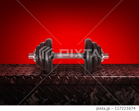 The dumbbell is placed on a metal plate. isolated on red background 117223874