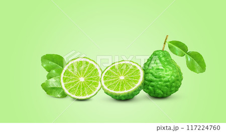 whole bergamot lime leaves and halved with bergamot lime leaves isolated on green background whole bergamot lime leaves and halved with bergamot lime leaves isolated on green background 117224760