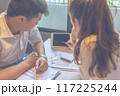 Young lady discussing with her partner showing data on tablet 117225244