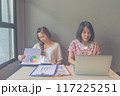 Two young freelancer women working on laptop and business paperwork 117225251