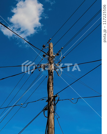 Old wooden electricity post with wires spreading in all directions 117225506