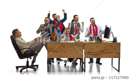 Soccer fans watching game and raising hands, shouting of joy their favorite team scoring goal against white studio background. 117227060