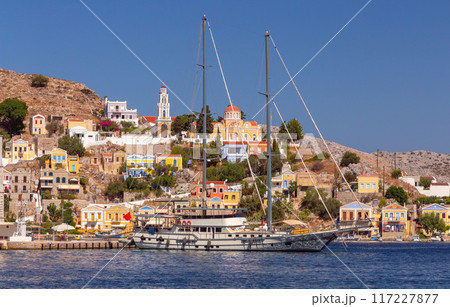 Bright colorful houses on the shore of the bay in the Greek fishing village Symi 117227877