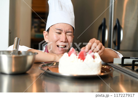 ケーキの盛り付け中に悩む男性パティシエ ケーキの盛り付け中に悩む男性パティシエ 117227917