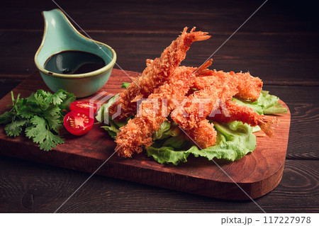 Fried shrimp, peeled in tempura, soy sauce, close-up, on a wooden board, 117227978
