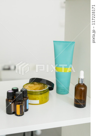 Close up of body care cosmetic products on shelf in cosmetology. Spa and piling cosmetics Close up of body care cosmetic products on shelf in cosmetology. Spa and piling cosmetics 117228171