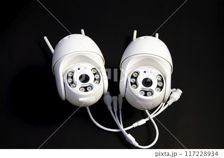 Two white IP cameras placed on a black background Two white IP cameras placed on a black background 117228934