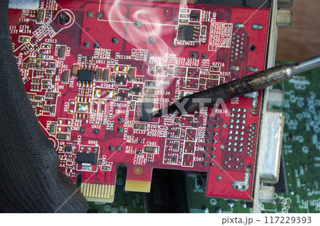 Motherboard repair parts soldering male close-up Motherboard repair parts soldering male close-up 117229393