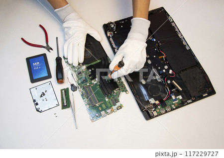 Top view. Technician repairing notebook computer, repairing motherboard and circuit. 117229727