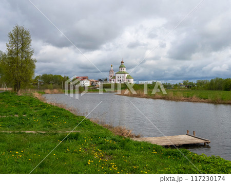 Wooden pier on the river against the background of the church. 117230174