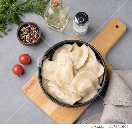 Dumplings with vegetables. Delicious vegetarian vareniki in a bowl on a wooden board Dumplings with vegetables. Delicious vegetarian vareniki in a bowl on a wooden board 117231605