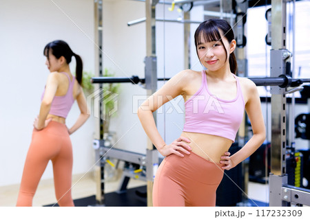 スポーツジムで体型をチェックする笑顔の若い女性 ダイエット パーソナルジム 筋トレ女子 美尻トレ スポーツジムで体型をチェックする笑顔の若い女性 ダイエット パーソナルジム 筋トレ女子 美尻トレ 117232309