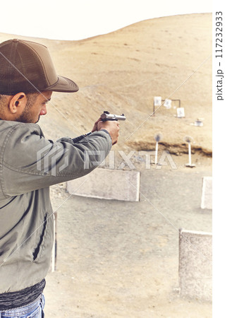 Man with hand gun aiming at shooting range and releasing stress. Selective Focus Man with hand gun aiming at shooting range and releasing stress. Selective Focus 117232933