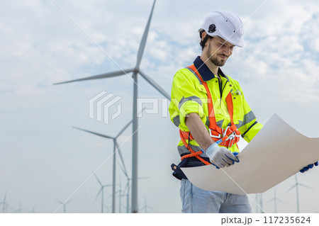 man engineer worker wearing safety uniform holding and reading blueprint man engineer worker wearing safety uniform holding and reading blueprint 117235624