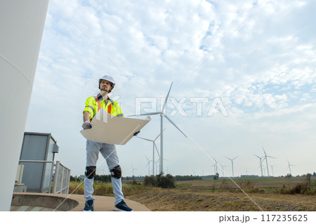 man engineer worker wearing safety uniform holding and reading blueprint man engineer worker wearing safety uniform holding and reading blueprint 117235625