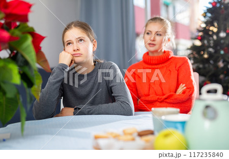 Schoolgirl sitting at the table after quarrel with mother 117235840
