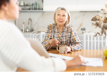 Real estate agent consulting elderly woman in home Real estate agent consulting elderly woman in home 117235920