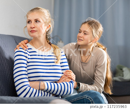 Upset woman sitting on sofa after quarrel Upset woman sitting on sofa after quarrel 117235963