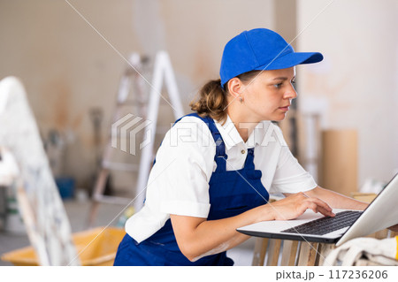Woman builder using laptop in construction site 117236206