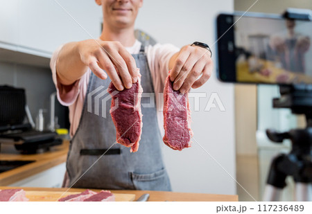 The chef is broadcasting live from workshop how to prepare a beef steaks on the electric grill The chef is broadcasting live from workshop how to prepare a beef steaks on the electric grill 117236489